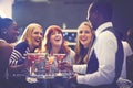 Hell make sure they dont get thirsty. a cocktail waiter serving drinks to a group of friends in a nightclub. Royalty Free Stock Photo