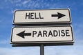 White two street signs with arrow on metal pole with word hell and paradise Royalty Free Stock Photo