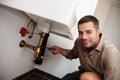 Hell work magic on your pipes. Portrait of an attractive young man fixing a pipe underneath the basin.