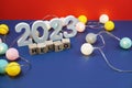 Hello 2023 alphabet letter and alarm clock decorate with LED cotton ball on blue and red background