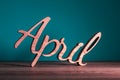 Hello April wooden texe written on dark background. Spring time concept