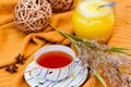 Hello Autumn background. Bright yellow wool sweater, cup of tea, honey, vine balls, anise stars and a spikelet