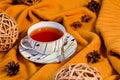 Hello Autumn background. Bright yellow wool sweater, cup of tea, natural decorative vine ball, star anise and pine cones Royalty Free Stock Photo