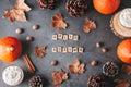 Hello autumn card with natural pine cones, pumpkins, dried leaves and pumpkin latte on dark grey stone top, top view, copy space.