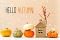 Hello autumn message with pumpkins with a house