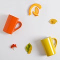 Hello autumn, yellow and orange cups lie on a white background. Flat lay, copy space