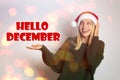 Hello December greeting card. Happy woman in Santa hat on white background, bokeh effect Royalty Free Stock Photo