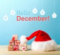 Hello December message with a Santa hat and gift boxes Royalty Free Stock Photo