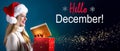 Hello December message with woman opening a gift box Royalty Free Stock Photo