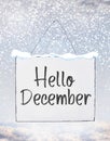 Hello December text on white plate board banner with cold snow f