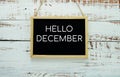 Hello December typography text on blackboard hanging against on the wall background Royalty Free Stock Photo