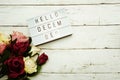 Hello December Word on Light box with roses flower bouquet on wooden background