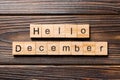 Hello december word written on wood block. hello december text on table, concept