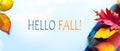 Hello fall message with Autumn leaves and Warm scarf on a blue background