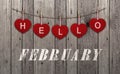Hello February Written On Hanging Red Hearts And Old Wooden Background