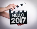 Hello 2017. Female hands holding movie clapper