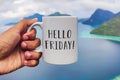 Hello Friday greeting on white coffee or tea cup in hand Royalty Free Stock Photo