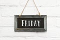 Hello friday text on hanging board white brick outdoor wall