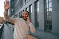 Hello gesture by a hand. Handsome black man is outdoors near the business building Royalty Free Stock Photo