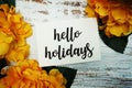 Hello Holiday Card with Blooming flower on wooden background