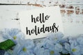 Hello Holiday Card with Blooming flower on wooden background