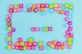 Hello inscription made of colorful cube beads with letters. Festive blue background concept with copy space