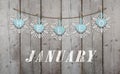 Hello january written on hanging ice blue hearts and white wooden snowflakes