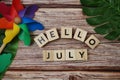 Hello July message alphabet letter on wooden background