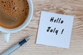 Hello July - message at home or office desk. With morning cup of coffee. Summer is Here concept