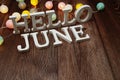 Hello June alphabet letters with LED cotton balls decoration on wooden background