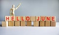 Hello June word written on wood block. Hello June text on table, concept. Wooden model of human