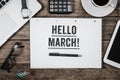 Hello March statement on notepad on office desk from above