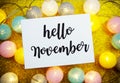 Hello November text on paper card with LED cotton balls decorate on Yellow background Royalty Free Stock Photo