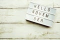 Hello November Word on Light box with roses flower bouquet on wooden background Royalty Free Stock Photo