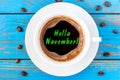 Hello November written on coffee cup at blue wooden surface. Autumn time concept, Top view