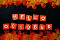 Hello October alphabet letter with maple leave decoration on black glitter background