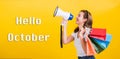 Hello October, Portrait Asian beautiful happy young woman smiling hold shopping bags multicolor and shouting in megaphone Royalty Free Stock Photo