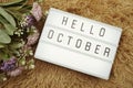 Hello October word in light box and flower bouquet