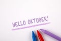 HELLO OKTOBER. Autumn, halloween, time planning and communication concept. Crayons on a white paper