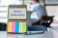 Hello Saturday text on note paper or empty reminder template on wooden table. New Goal New Start concept