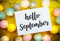 Hello September text on paper card with LED cotton balls decorate on yellow background Royalty Free Stock Photo