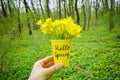 Hello spring! Spring yellow flowers in the yellow cup with the inscription hello spring