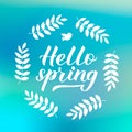 Hello spring calligraphy lettering with floral wreath frame on green blue blurred background. Inspirational seasonal quote Royalty Free Stock Photo