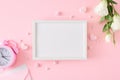 Flat lay photo of white spring flowers, pink alarm clock, envelope, hearts on pastel pink background Royalty Free Stock Photo