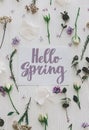 Hello spring floral greeting card, handwritten greetings on white paper card and lilac, roses and eucalyptus branches and flowers