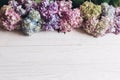 Hello spring. Happy mothers day. Women day. Beautiful hydrangea flowers on rustic white wood, flat lay. Colorful pink,blue,green,