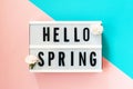 Hello Spring - text on lightbox with carnations on blue and pink background Royalty Free Stock Photo