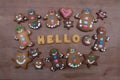 Hello text with biscuit letters and gingerbread cookies on a wooden board