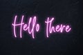 Hello there written in pink neon style on black background Royalty Free Stock Photo