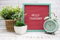 Hello Thursday text on Letter Board with alarm clcok and artificial plant decoration Royalty Free Stock Photo